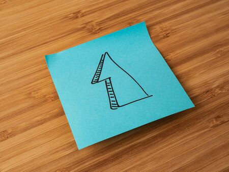 Sticker depicting the number one. Paper sticker pasted on a wooden surface. Self-adhesive paper sheet. A piece of paper on a wooden board. Reminder for action. Paper sheet for notes.の写真素材