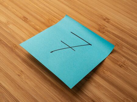 Sticker depicting the number seven. Paper sticker pasted on a wooden surface. Self-adhesive paper sheet. A piece of paper on a wooden board. Reminder for action. Paper sheet for notes.の写真素材