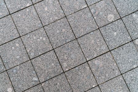 Background image of pavement surface. Wallpaper. Substrate for text. Detailed texture of a pedestrian walkway with paving tiles. Paving slabs in the exterior.の写真素材