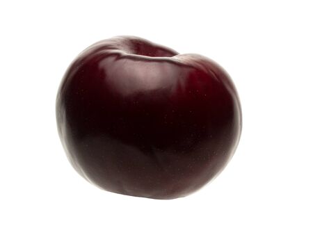 Isolated object on a white background. The shape of the plum fruit is round. Ripe drupe of lilac and violet color with a bluish coating. Autumn harvest of juicy plum fruits.の写真素材