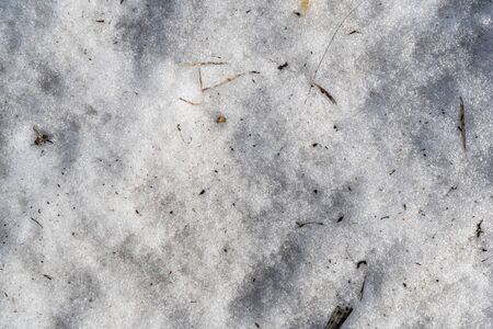 The texture of dirty snow. Spring snow covered with mud. Background image of snowy texture. Background for text. Space for text. Wallpaper. Top view. Spring snow drifts begin to melt.の写真素材
