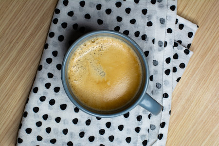 Americano in a gray mug on a towel on a wooden tableの写真素材