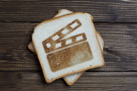 toast with a movie sign on dark wood. Crackers burnt on bread. film production.
