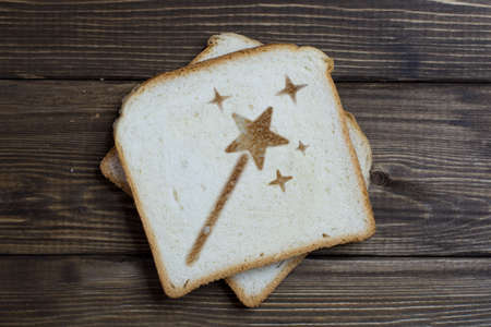 toast with the sign of the magic wand on dark wood. Magic flies out of the wand in sparks. little...