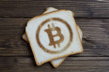 toast with bitcoin sign on dark wood. Cryptocurrency trading.の写真素材
