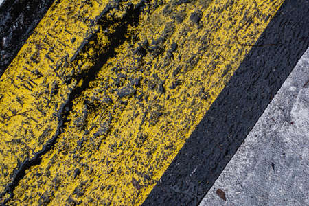 Asphalt texture covered with white and yellow paint.の写真素材