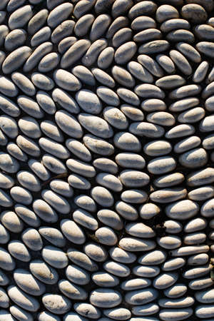 pebble texture macro photography. The pebbles are neatly arranged in a swirling pattern.の写真素材
