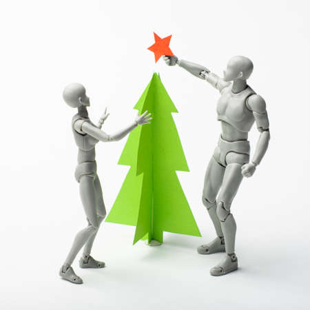 Dress up the spruce for the new year. Celebrating Christmas. Models decorate the Christmas tree. Installing a star on the top of the spruce.の写真素材