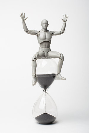 Male figurine and hourglass. It's time to act! manage your time. now or never.の写真素材