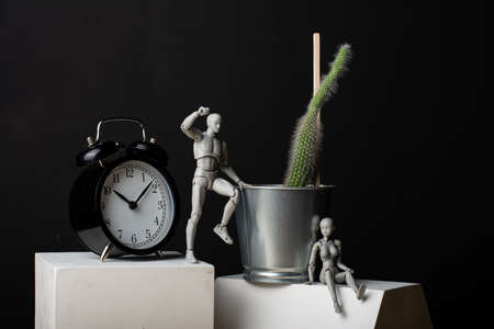 The man is trying to climb up to the cacus. A woman sits leaning on an iron pot.の写真素材