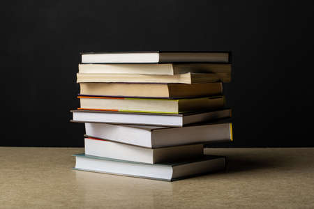 A stack of books lies on a plywood sheet. Composition in the dark key.の写真素材