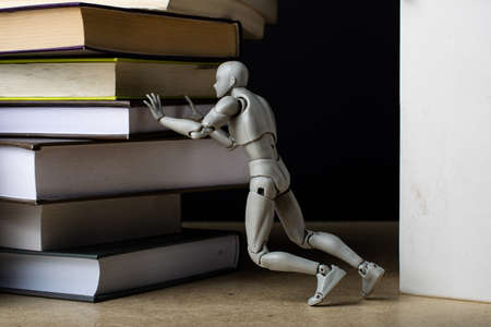 A man pushes a stack of books forward.の写真素材