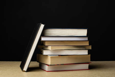 A stack of books lies on a plywood sheet. Composition in the dark key.の写真素材