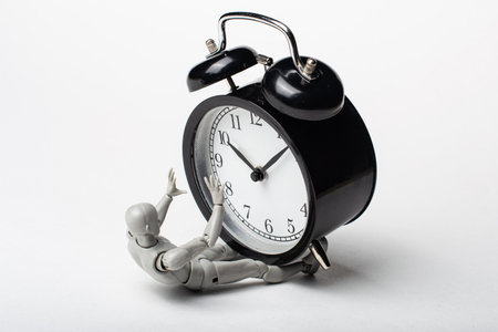 The man was crushed by an alarm clock. The man lies under the clock. Didn't make it on time. Deadlines are running out.の写真素材