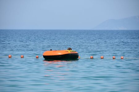 vlora albania august a boy in a colorful inflated trendy floating blue seaの写真素材