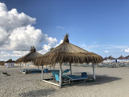 Beach Chairs and Umbrella on a beautiful bach in Durres, Albania.textの写真素材
