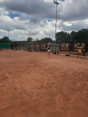 Tennis court Stadium red ground in sunset , clouds in the sky.のeditorial素材