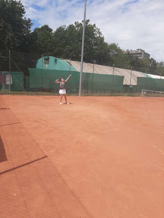 Tennis court Stadium red ground in sunset , clouds in the sky.のeditorial素材