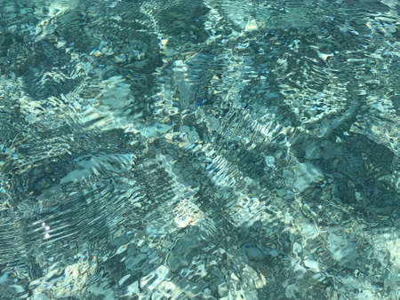 Ripples on transparent emerald green water.Top view.の写真素材