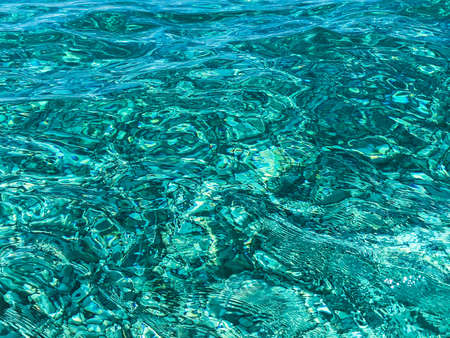 Ripples on transparent emerald green water.Top view.の写真素材