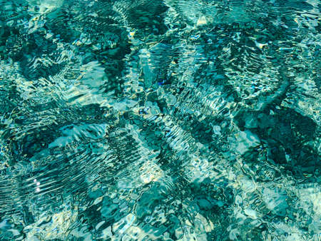 Ripples on transparent emerald green water.Top view.の写真素材
