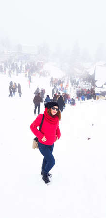Lonely girl in the red coat posing on minimalist background,のeditorial素材