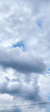 The vast blue sky and clouds create a beautiful sky background.の写真素材
