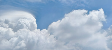 White fluffy clouds in the blue sky. Panoramic image.