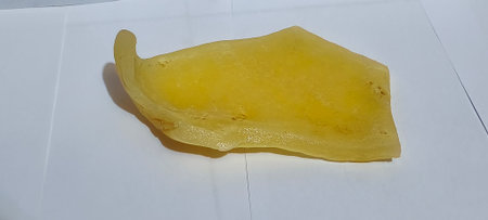 A closeup shot of a slice of mango on a white backgroundの写真素材