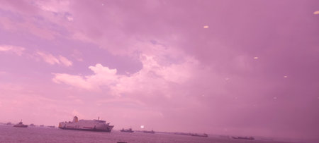Cargo ship in the sea at sunset with pink sky background.のeditorial素材