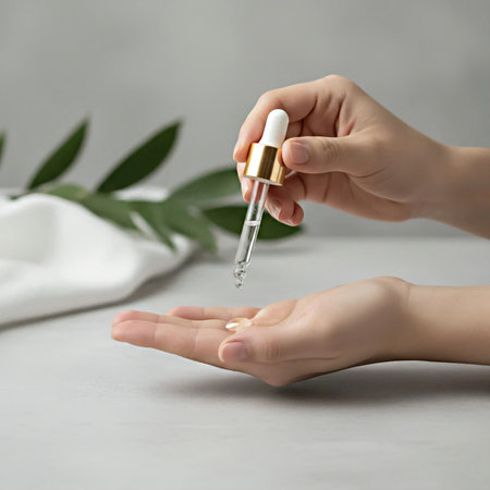 Female hands holding pipette with serum on grey background, closeupの素材