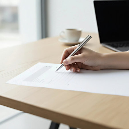 Close-up of businesswoman writing on paper at workplace in officeの素材