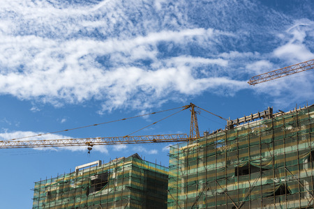 Tower crane at the construction site of blue sky and white clouds.