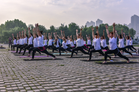 Organized women practice yoga in urban parks. June 21, 2018, North River Park, Luannan County, Tangshan City, Hebei, Chinaのeditorial素材