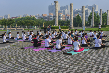 Organized women practice yoga in urban parks. June 21, 2018, North River Park, Luannan County, Tangshan City, Hebei, Chinaのeditorial素材