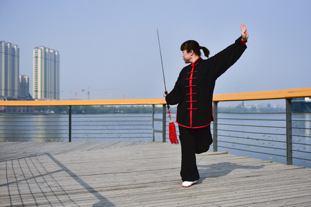 Luannan County, Hebei Province, China - May 11, 2019: an Asian woman practices Chinese Taijiquan in a park as a fitness exercise.のeditorial素材