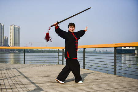 Luannan County, Hebei Province, China - May 11, 2019: an Asian woman practices Chinese Taijiquan in a park as a fitness exercise.のeditorial素材