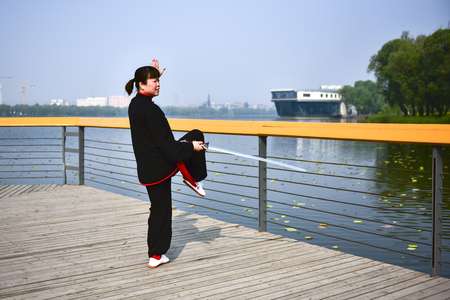 Luannan County, Hebei Province, China - May 11, 2019: an Asian woman practices Chinese Taijiquan in a park as a fitness exercise.のeditorial素材