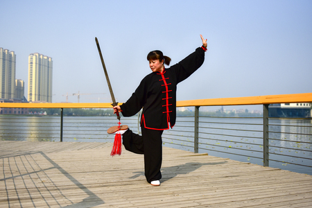 Luannan County, Hebei Province, China - May 11, 2019: an Asian woman practices Chinese Taijiquan in a park as a fitness exercise.のeditorial素材
