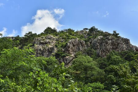 Peaks and forest landscape in the background of blue sky and white clouds. Photographed in Dagushan, Dandong, Liaoning, Chinaの写真素材