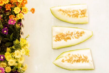 Under the white background, the cut wax gourd is decorated with flowers.の写真素材