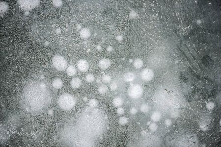 The background of naturally formed ice flower texture on the frozen river in winter 