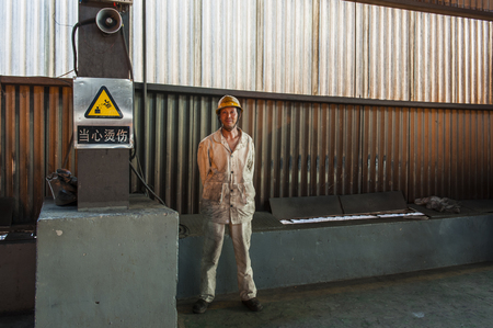 Luanan county, hebei province, China -- June 14, 2014: steelworkers work in the control room and workshop of a steel mill.のeditorial素材