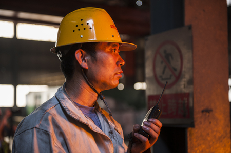 Luanan county, hebei province, China -- June 14, 2014: steelworkers work in the control room and workshop of a steel mill.のeditorial素材