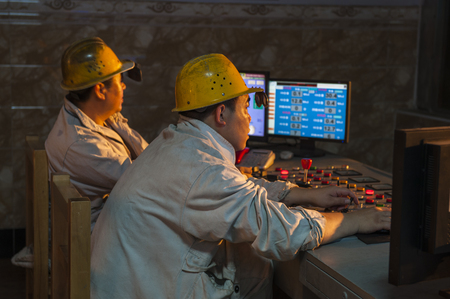 Luanan county, hebei province, China -- June 14, 2014: steelworkers work in the control room and workshop of a steel mill.のeditorial素材