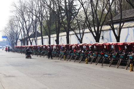 Tricycle lining in a lane at the side of a street