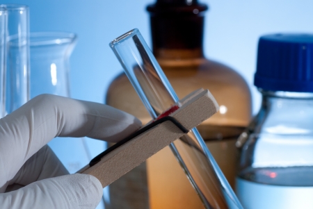 Hand holding a test-tube by test tube holderの写真素材