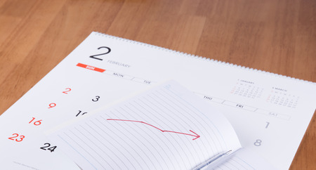 Notebook and pen on a calendarの写真素材