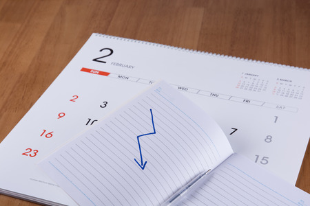 Notebook and pen on a calendarの写真素材