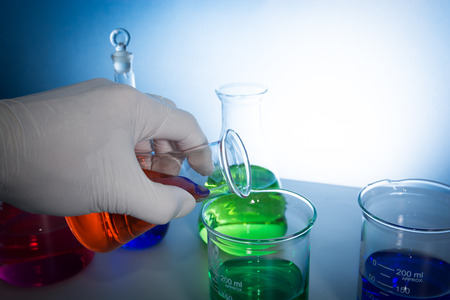 a scientist make experiments with glass laboratory apparatusの写真素材